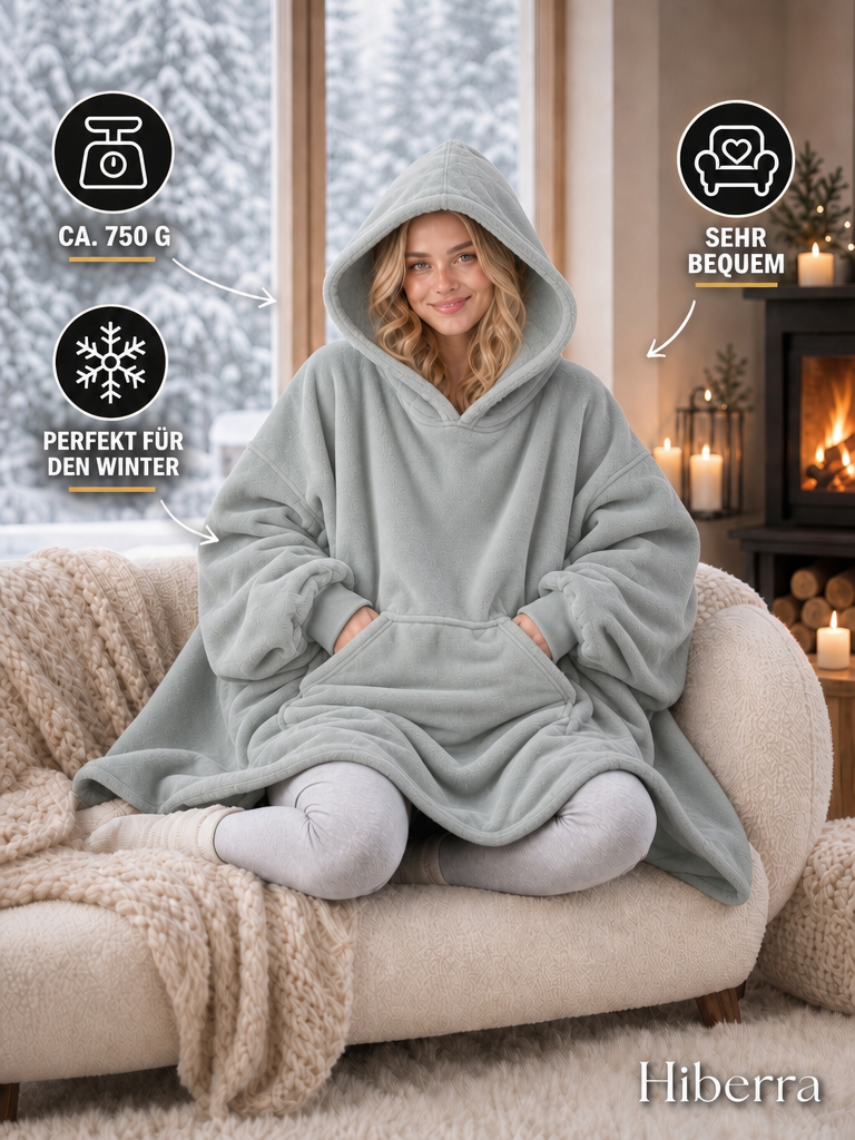 Frau in der hellgrauen Hiberra Hoodie-Decke auf dem Sofa, ca. 750 g – Farbe Hellgrau