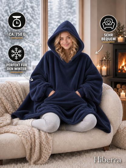 Frau in der marineblauen Hiberra Hoodie-Decke auf dem Sofa, ca. 750 g – Farbe Marineblau