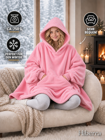Frau in der rosa Hiberra Hoodie-Decke auf dem Sofa, ca. 750 g – Farbe Rosa