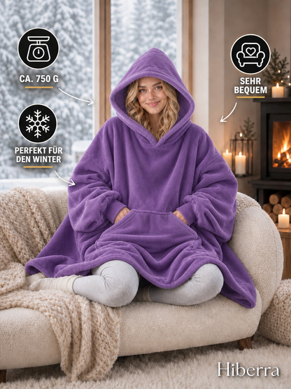 Frau in der lila Hiberra Hoodie-Decke auf dem Sofa, ca. 750 g – Farbe Lila