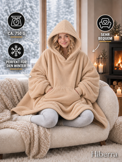 Frau in der beigen Hiberra Hoodie-Decke auf dem Sofa, ca. 750 g – Farbe Beige