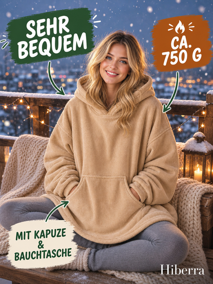 Frau in der beigen Hiberra Hoodie-Decke sitzt auf dem verschneiten Balkon, ca. 750 g – Farbe Beige
