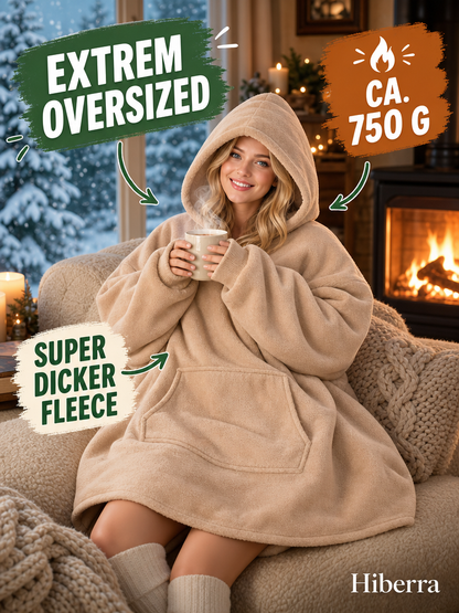 Frau in der beigen Hiberra Hoodie-Decke mit Tee am Kamin, ca. 750 g – Farbe Beige